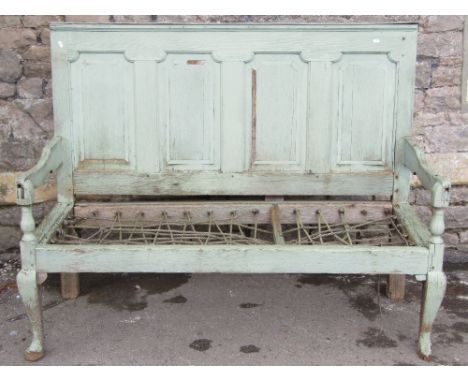 A Georgian oak settle/bench with moulded panelled back over open arms and strung seat (lacks cushion), raised on shaped forel