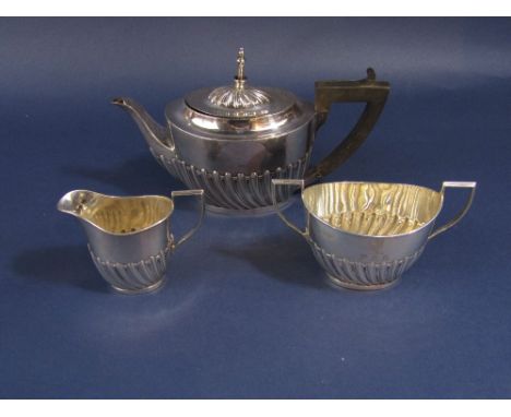 Late Victorian three piece tea service comprising teapot, milk jug and twin handled sucrier, all with half fluted decoration,