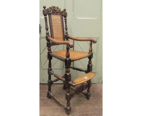 An unusual child's high chair in the Carolean manner, the beechwood frame with turned mouldings and adjustable step, the cane