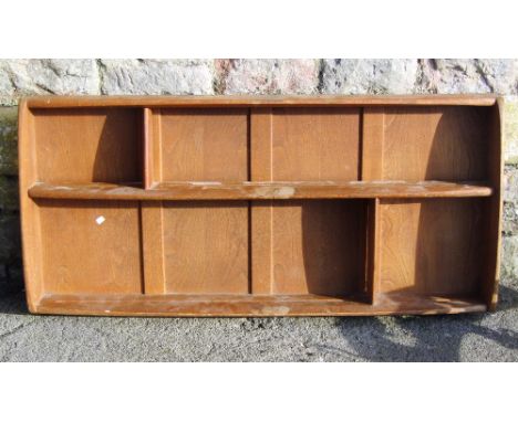 An Ercol medium elm wall hanging plate rack with segmented shelves 
