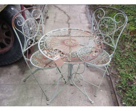 A weathered contemporary light steel terrace table of circular form with scrollwork detail, together with a pair of matching 