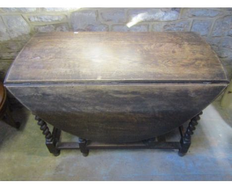 A 1920s oak oval drop leaf gateleg dining table raised on six barley twist supports, together with an Edwardian/1920s mahogan