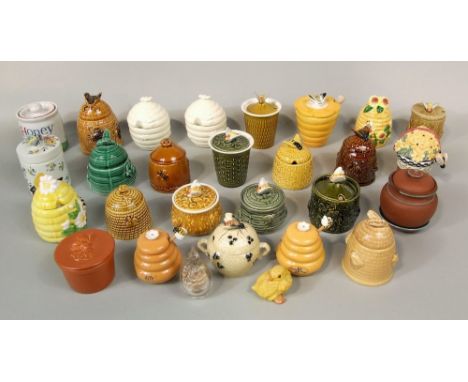 A collection of various ceramic honey pots including examples in the form of bee skeps, etc
