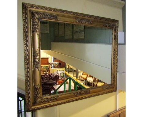 A carved and gilded period frame with repeating floral and geometric detail enclosing a later mirror plate (to accept a portr