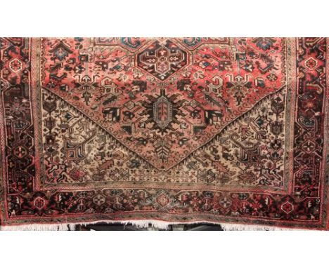 Iranian thick weave carpet decorated with various foliate panels upon a light red ground