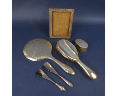 A mixed collection of silver to include two dressing brushes, a dressing mirror, two silver handled shoehorns and a silver mo