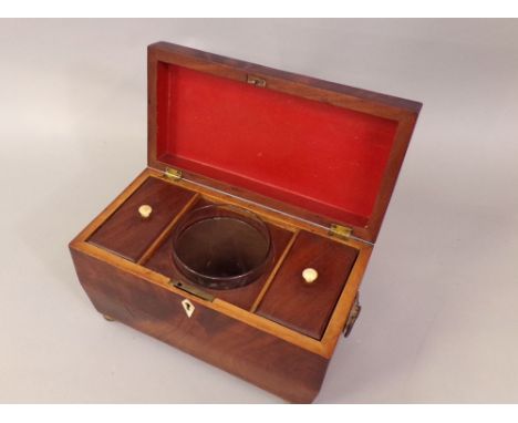 19th century flame mahogany sarcophagus tea caddy, the hinged lid enclosing an interior of fitted glass mixing bowls, the cad