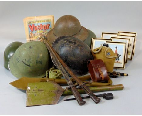 A mixed militaria lot to include various helmets, bayonets, tools, etc, together with a flask and various framed military pri