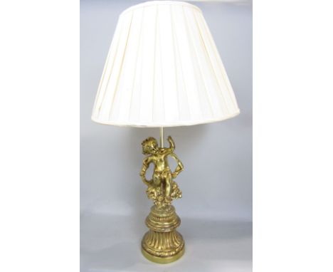 Cast gilt metal figural table lamp in the form of a seated cherub on a bouquet of flowers on a fluted tapered stepped circula