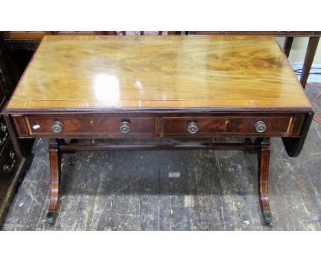 A Regency mahogany sofa table, having two real and two dummy drawers, raised on swept end supports and united by a central st
