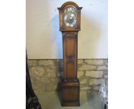 An Edwardian 1920's grandmother clock, the oak case with applied beaded and further mouldings, arched hood and brass dial, th