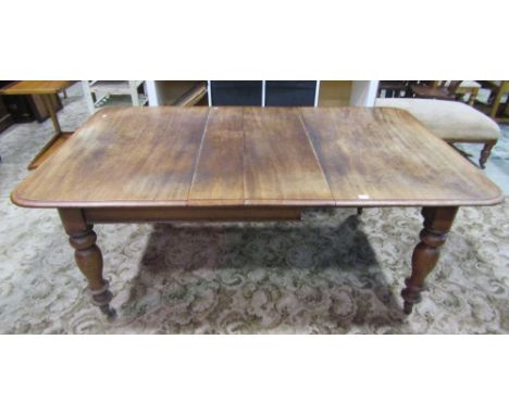 A Victorian mahogany pull-out extending dining table of rectangular form with moulded outline, rounded corners and two small 