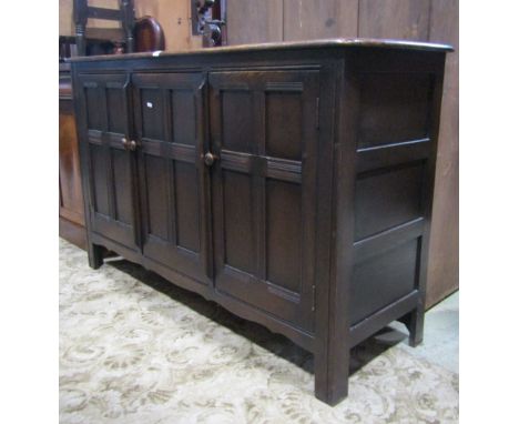 An Ercol elm sideboard enclosed by three quarter panelled doors, partially fitted, 150 cm wide