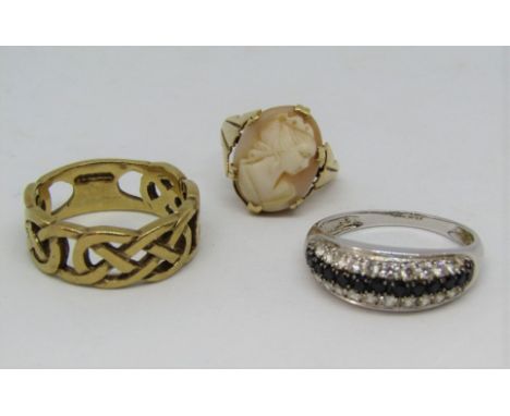 Three gold rings comprising a 14k white gold dress ring, a 9ct Celtic style wedding ring and a further 9ct cameo example, siz