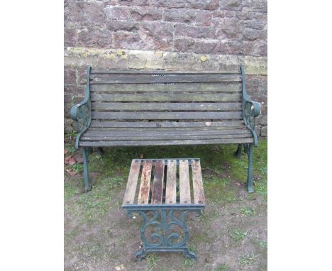 A contemporary two seat garden bench with weathered timber lathes, raised on a pair of cast iron end supports, 130cm long app