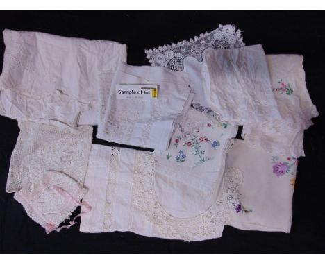 A collection of vintage white table linen including cloths with pulled threadwork, colourful embroidery and crochet edging, t