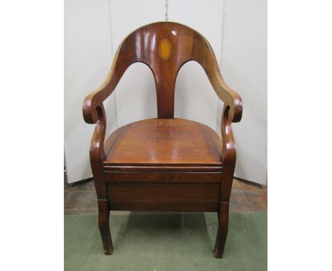 An early 19th century mahogany commode elbow chair with horseshoe shaped back and conch shell inlaid detail, with rising seat