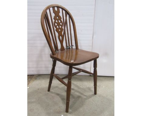 A set of four traditional Windsor wheel back dining chairs with stick backs