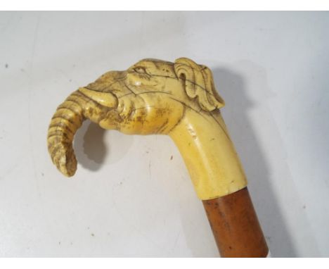 A 19th century walking stick with carved ivory handle in the form of an elephant with a horn ferrule, approx length including