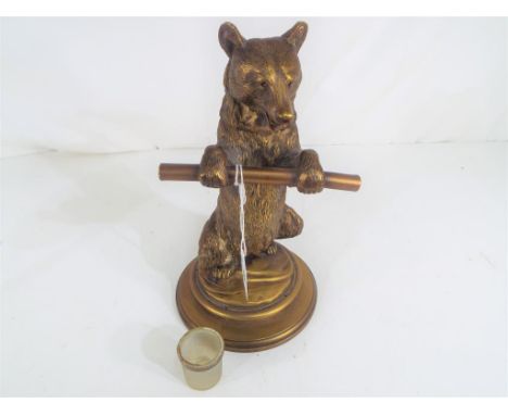 A 19th century Continental brass figural inkwell formed as a standing bear holding a staff with glass liner, set on a circula