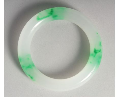 A CHINESE TWO TONE JADE BANGLE. 3.25ins diameter.