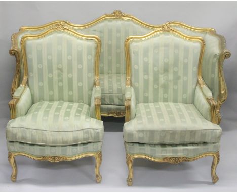 A FRENCH STYLE GILTWOOD THREE PIECE SUITE, comprising three seater settee and a pair of matching armchairs upholstered in a c