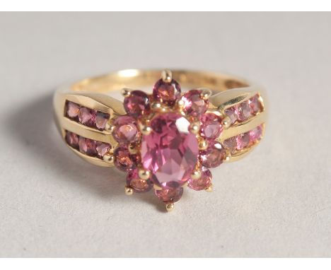 A 14CT GOLD RUBY CLUSTER RING.