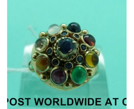 A yellow metal ring set with sapphires, emerald, garnet, ruby, moonstone, citrine and tigers eye (size N)
