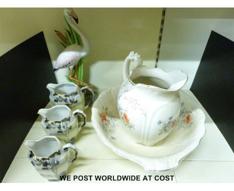 A jug and basin washing set and three graduated jugs and a large ceramic flamingo