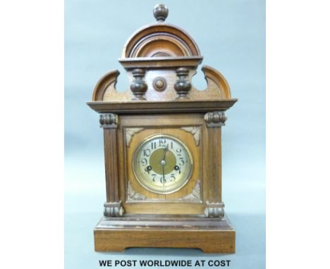 A mahogany and oak cased mantel clock with carved, fluted and turned decoration to the case, the brass dial with silvered cha