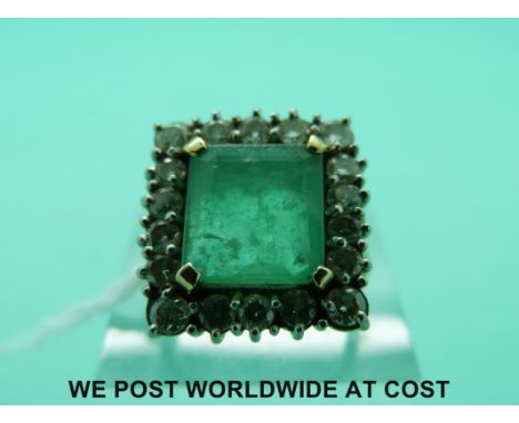 An 18ct gold ring set with a large square cut emerald surrounded by round cut diamonds in a square setting (size M)