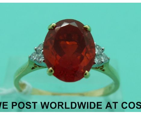 An 18ct gold ring set with a large oval cut fire opal and three diamonds to each shoulder (size U)