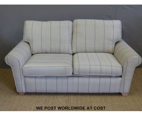A modern two seater sofa bed with scatter cushions