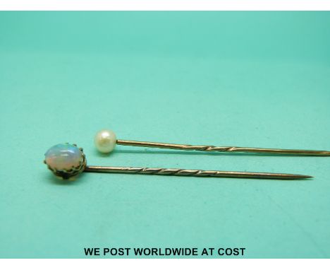 A 9ct gold stick pin set with an opal cabochon and a gold stick pin set with a pearl 