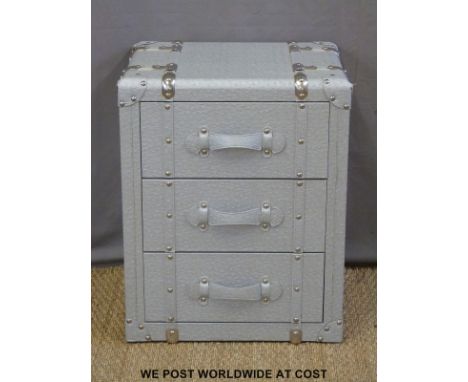 A chest of three drawers modelled as a vintage metal bound steamer trunk