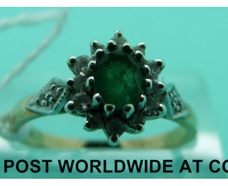 A 9ct gold ring set with an emerald surrounded by diamonds (size M)