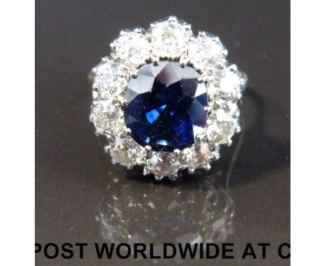 A Victorian ring marked 18ct set with a 4.86ct oval cushion cut natural untreated sapphire surrounded by old cut diamonds eac