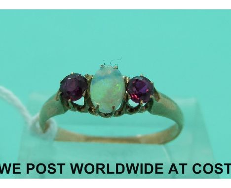 A yellow metal ring set with opal cabochon and two rubies (size L)