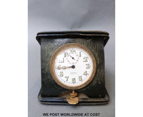 A Swiss 8 day leather cased travelling clock by Walker and Hall, the white enamelled dial with bold luminous Arabic numerals,
