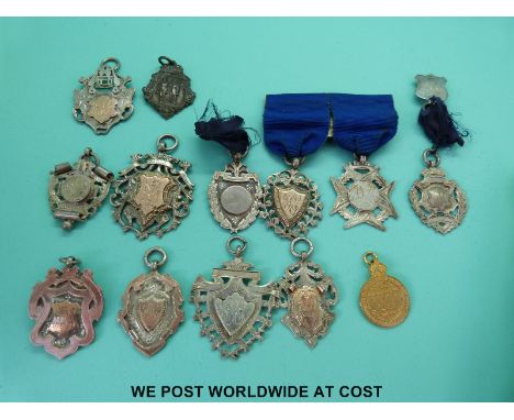 A collection of hallmarked silver fobs awarded to Miss M Ingram gymnast, with newspaper article relating to her included