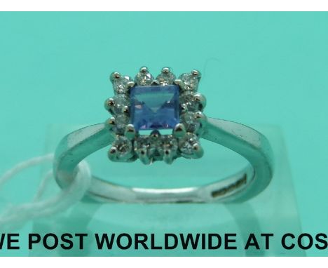 An 18ct white gold ring set with a square step cut tanzanite surrounded by diamonds (size N)