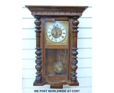 A c1910 two train wall clock in half bobbin turned case, the ivory coloured chapter ring with Roman numerals and sunburst cen