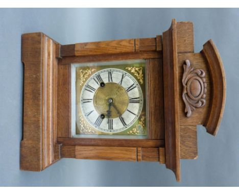 An oak cased mantel/shelf clock with silvered chapter ring on brass dial and decorative spandrels, beetle and poker style han