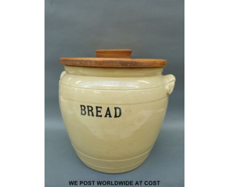 A very large ceramic bread bin with wooden lid stamped to underside "with the compliments of builders' supply stores of Coven