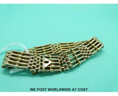 A yellow metal gate bracelet marked 9 with triangular clasp (23.1g) 