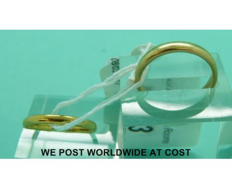 A 22ct gold wedding ring (2.6g, size N) and a yellow metal wedding ring (4.1g, size M)