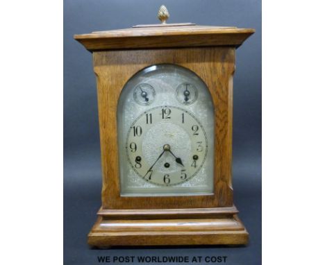 An oak cased German ting-tang bracket clock with silver chased dial, strike/silent subsidiary, Roman numerals and blued spade
