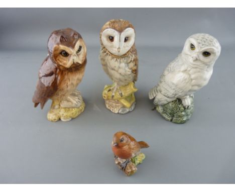 Three Royal Doulton owls for Whyte & Mackay Scotch whisky including a snowy owl, barn owl, short eared owl and a Beswick mode