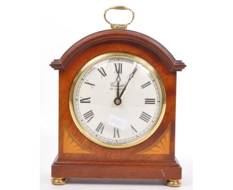 A Comitti of London mahogany inlaid bracket mantel clock with brass handle atop, brass finial feet, inset cylinder movement. 