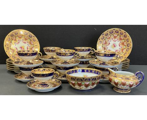 A Japanese Noritake porcelain tea service, intricately decorated with floral swags, gilt bands, with cobalt blue and red grou